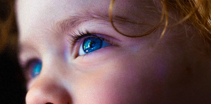 Nahaufnahme eines Kindergesichts mit blauen Augen