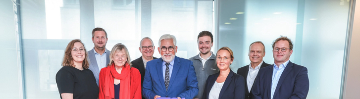 Gruppenfoto mehrerer Personen in Geschäftskleidung